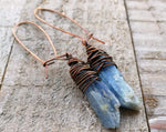 A pair of  Blue Kyanite Earrings close up on a wooden background