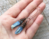 A pair of Blue Kyanite Earrings in hand.