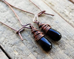 A close up of  Black Onyx Earrings on a wooden background.