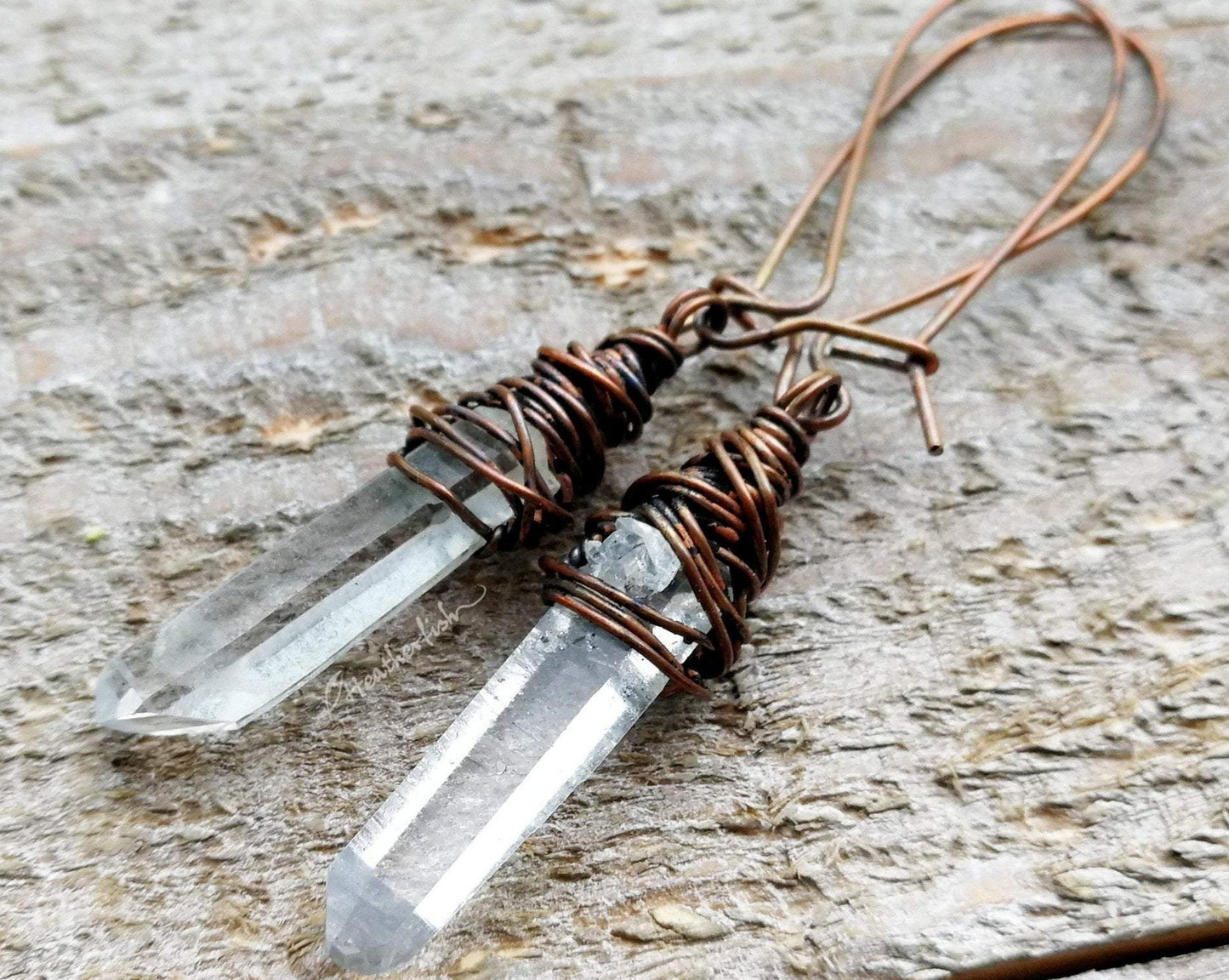 A Pair of crystal earrings displayed on a wood background