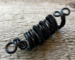 A side view of a Black Woven Dread Bead.