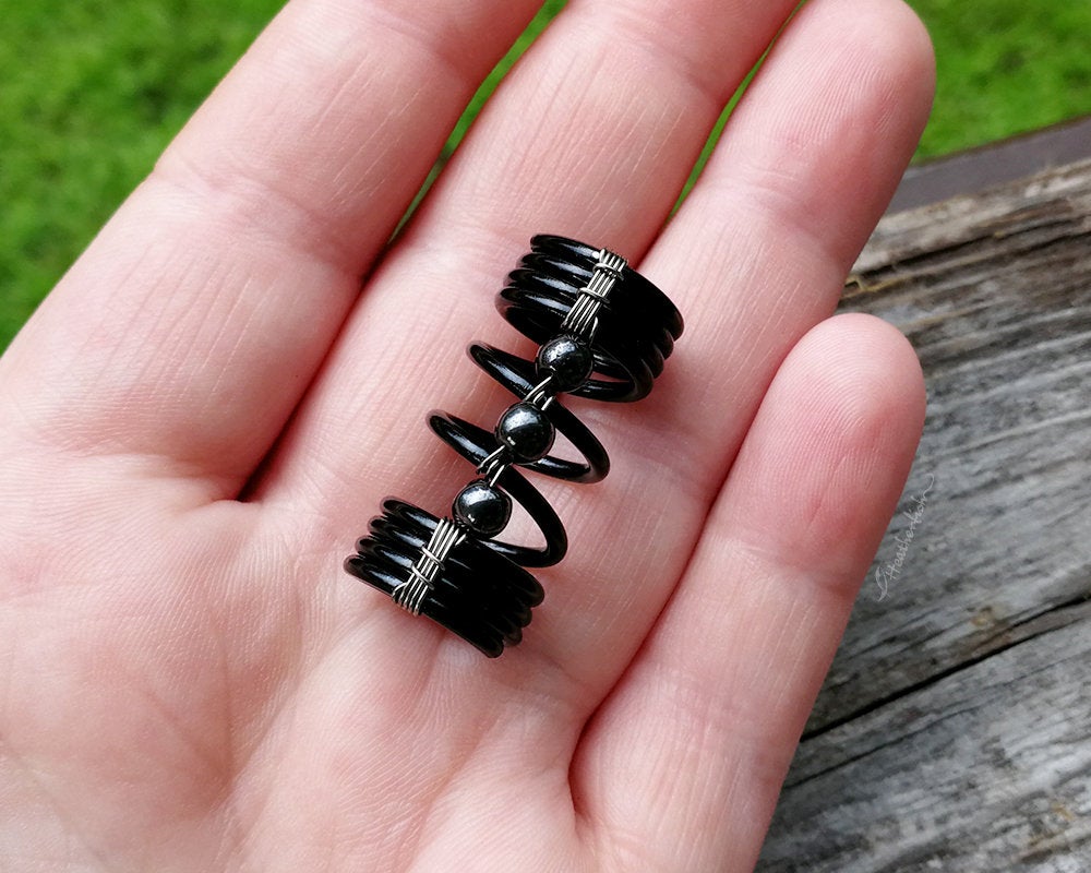 A top view of a Hematite Loc Bead in hand.