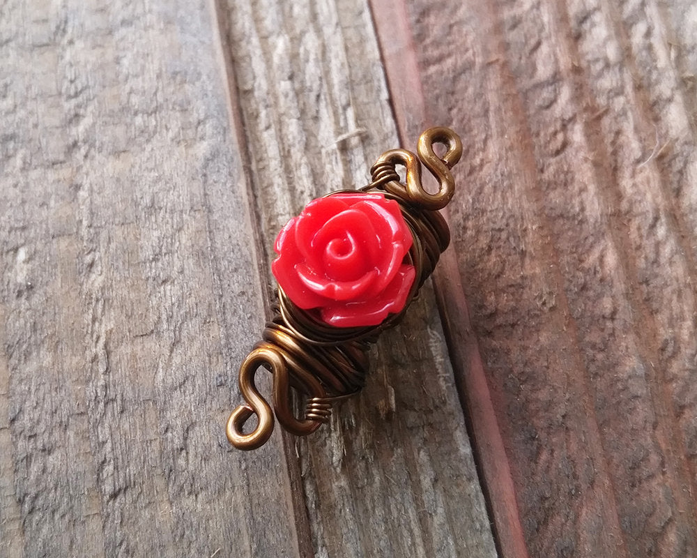 A top view of a Red Rose Dread Bead.