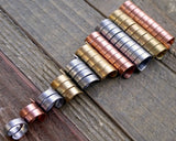 A top view of Mixed Metal Dread Beads Set of 10 in Varied Length in a row.