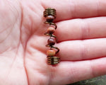 A top view of a Earthy Dreadlock Bead in hand.