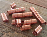 A side view of Copper Dread Beads Set of 10 in Varied Length.