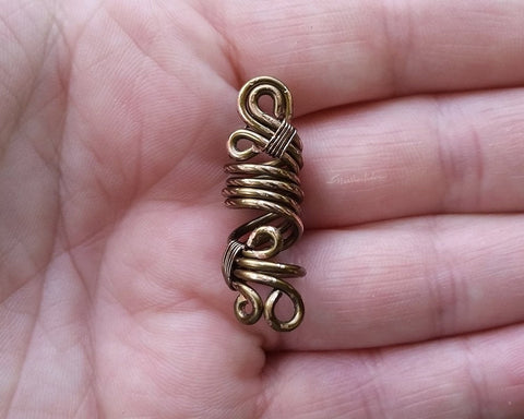 Close up view of a Rustic Filigree Dread Bead in hand.