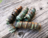 A side view of Patina Copper Dread Beads Set of 6.