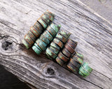 A back view of Patina Copper Dread Beads Set of 6 on a wooden background.