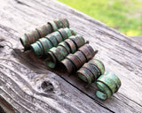 A side view of Patina Copper Dread Beads set of 6 in a row.
