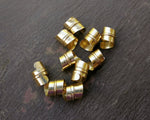A top view of Stylized Brass Dread Beads Set of 10.