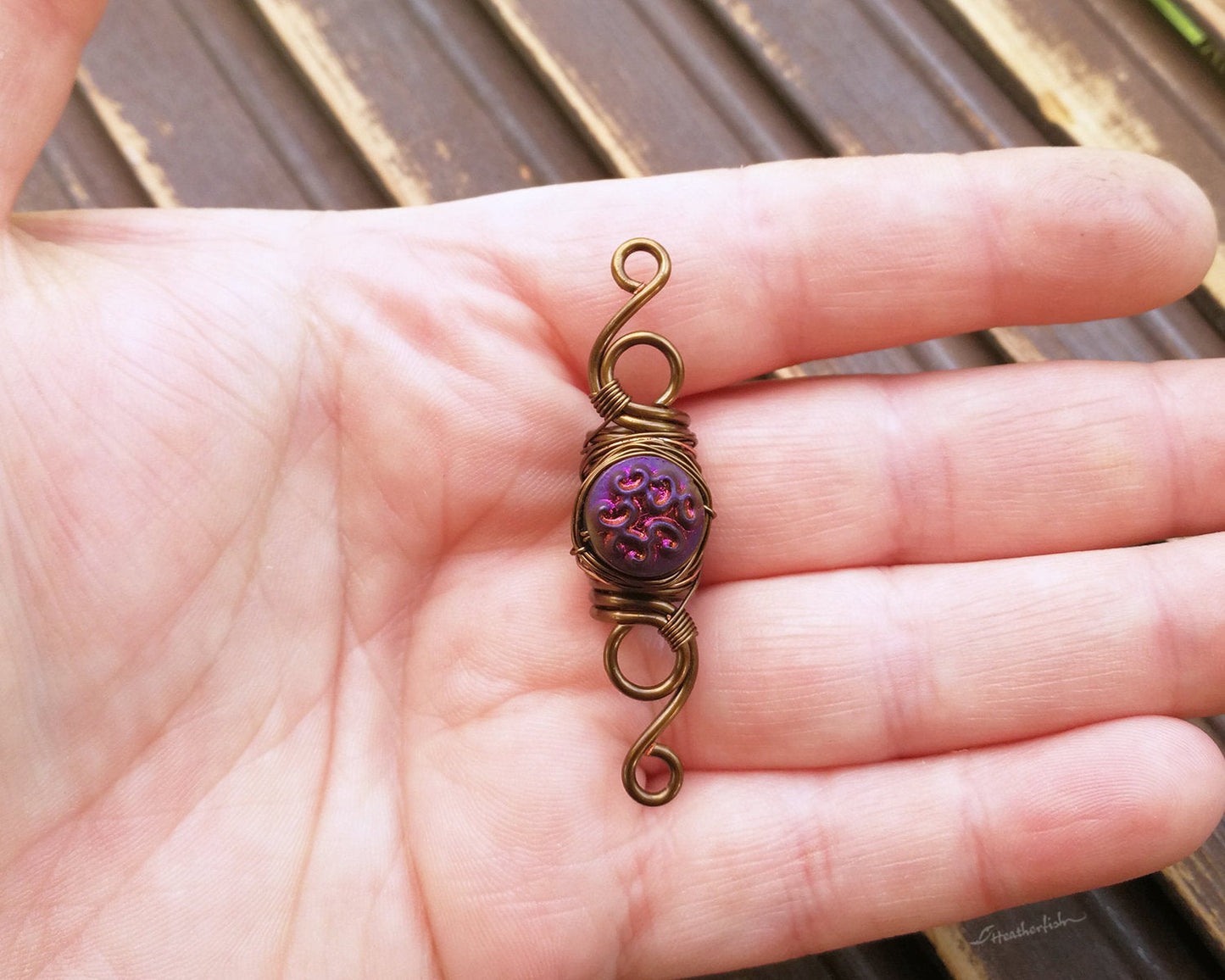 A top view of a Purple Czech Dread Bead in hand.