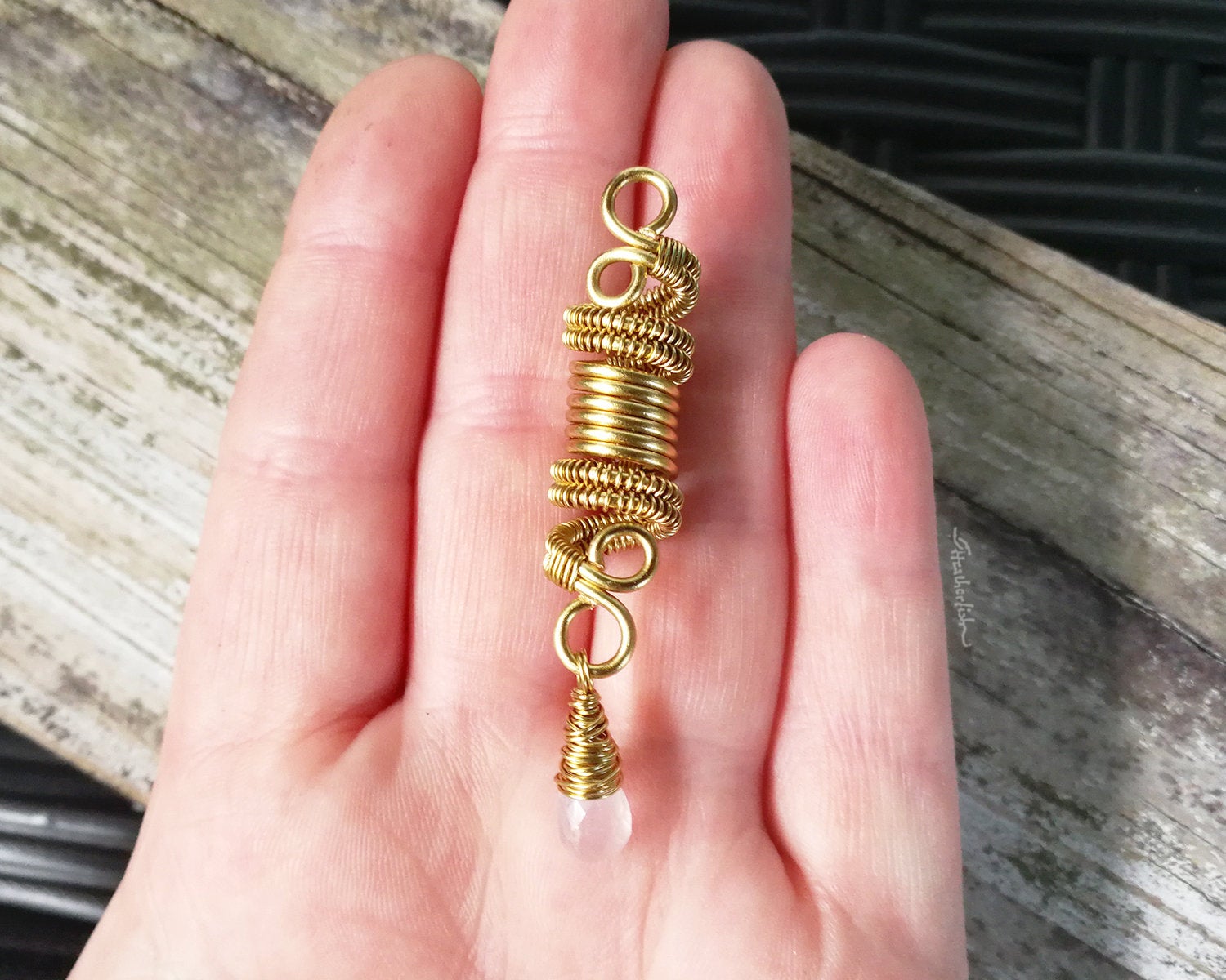 A top view of a Rose Quartz Dread Bead in hand.