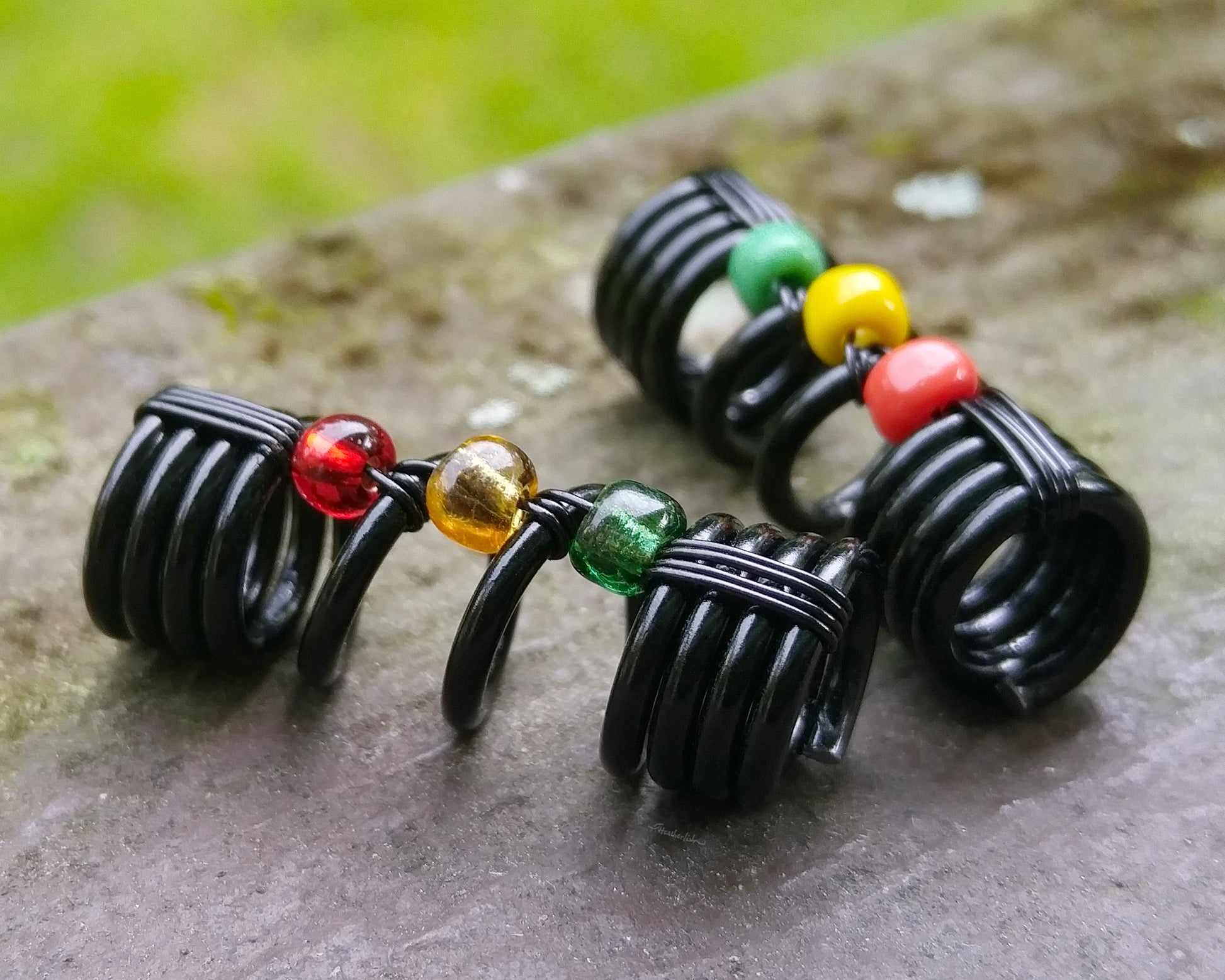 A close up view of One Rasta Dread Bead with options in Glass Bead Type.