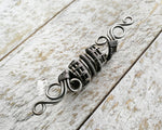 A side view of a Silver Filigree Dread Bead.