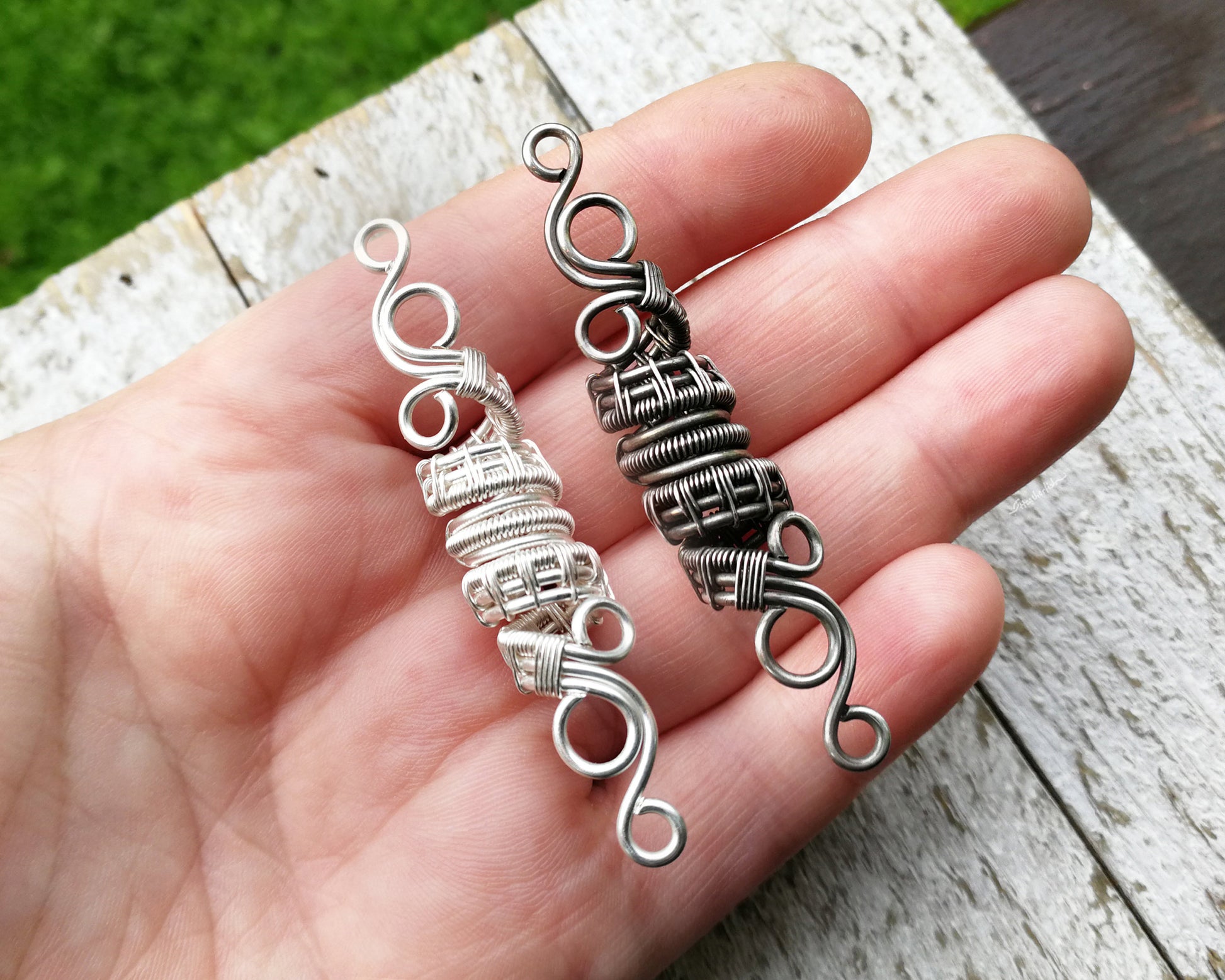 A top view of Silver Filigree Dread Bead side by side comparison of different finishes in hand.