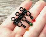A top view of Rasta Dread Beads Set of 3 Glass Drops in hand.