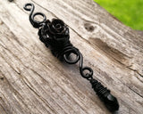 A side view of a Goth Dreadlock jewelry Black Rose.