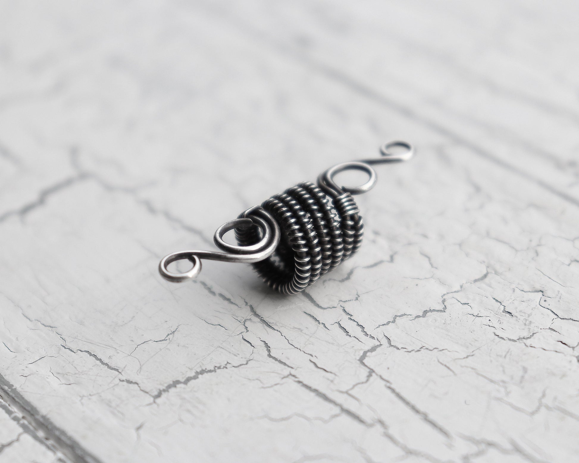 A back view of a Elegant Silver Dread Bead. 