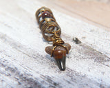A front view of a Shark Tooth Dread Bead with Wood Accents.