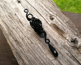 A top view of a Goth Dreadlock jewelry Black Rose.