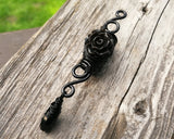 A top view of a Goth Dreadlock jewelry Black Rose.