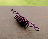 A back view of a Purple Woven Dread Bead.