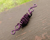 A top view of a Purple Woven Dread Bead.