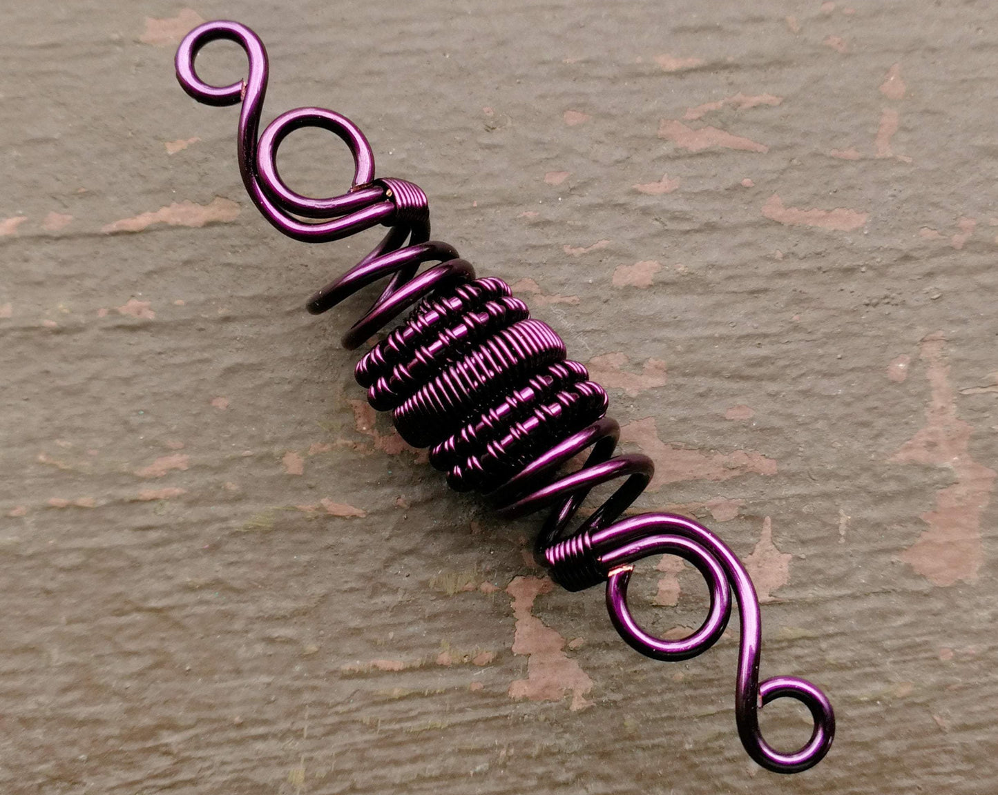 A close up view of a Purple Woven Dread Bead.