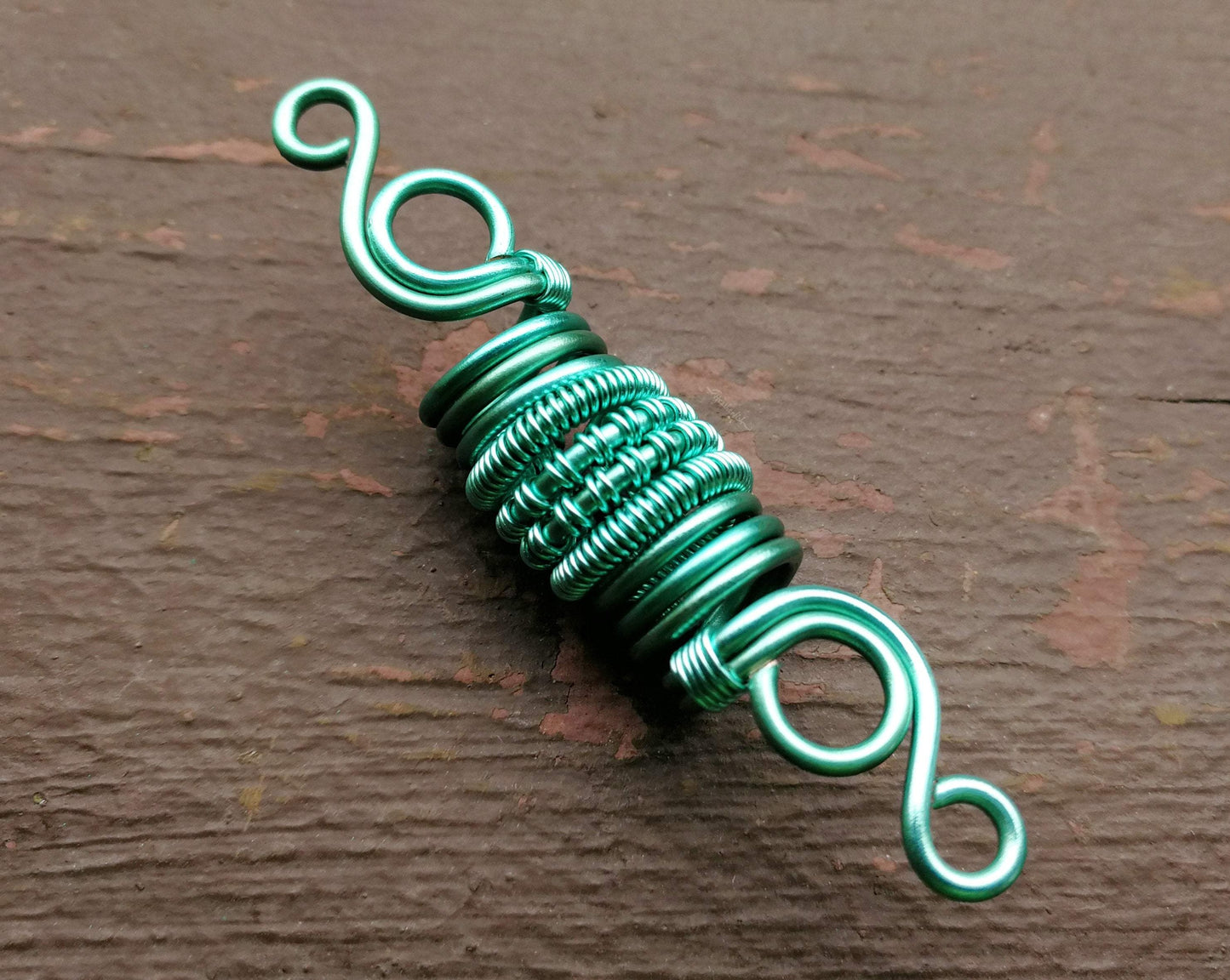 A close up view of a Woven Aqua Dread Bead.