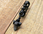 A side view of a Shark Tooth Dread Bead with Black Lava Beads.