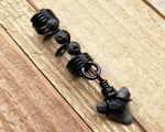 A close up view of a Shark Tooth Dread Bead with Black Lava Beads.