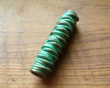 A back view of a Green Patina Copper Dread Bead.